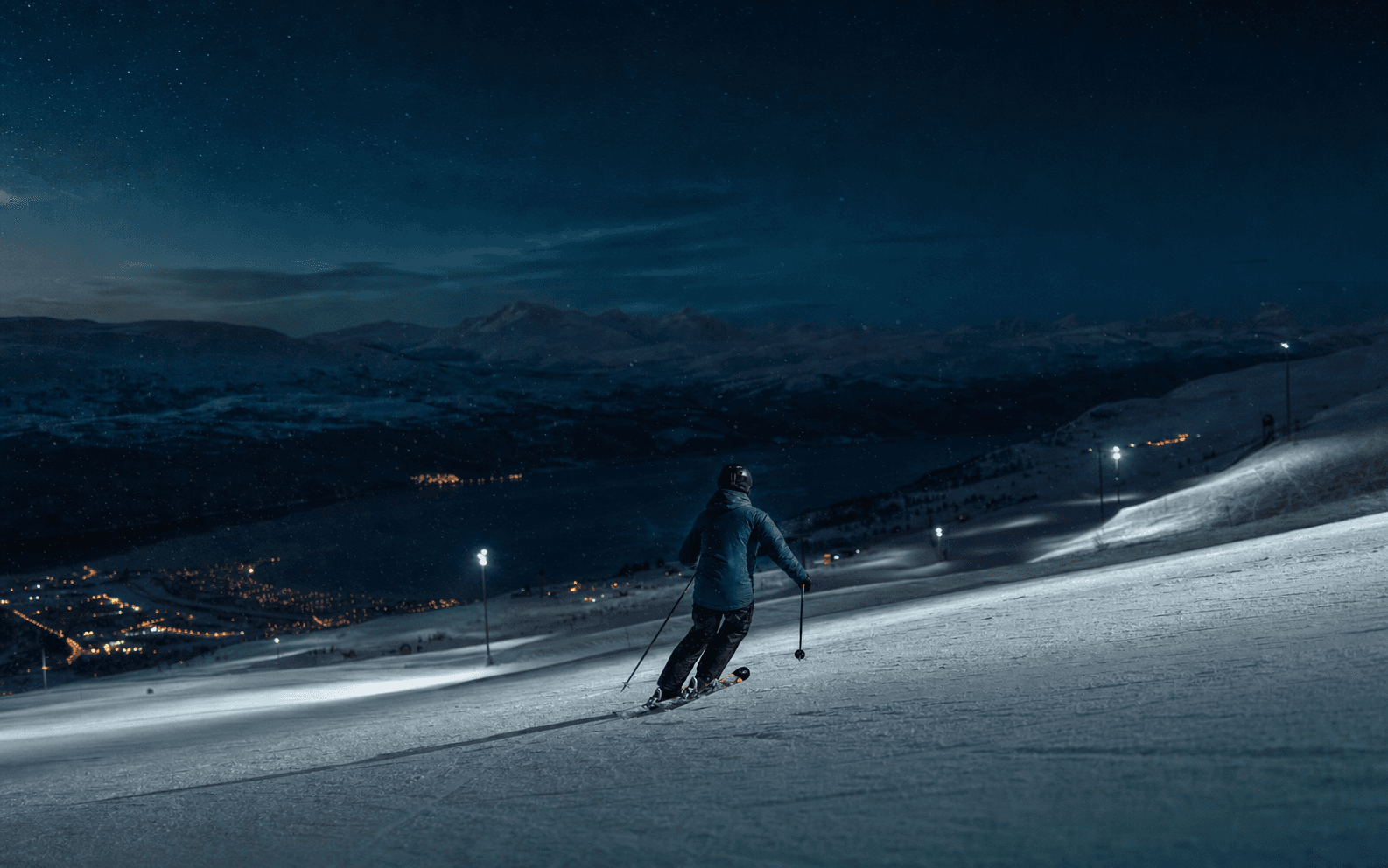 A skier beneath deep blue Nordic evening light on the slopes above Åre