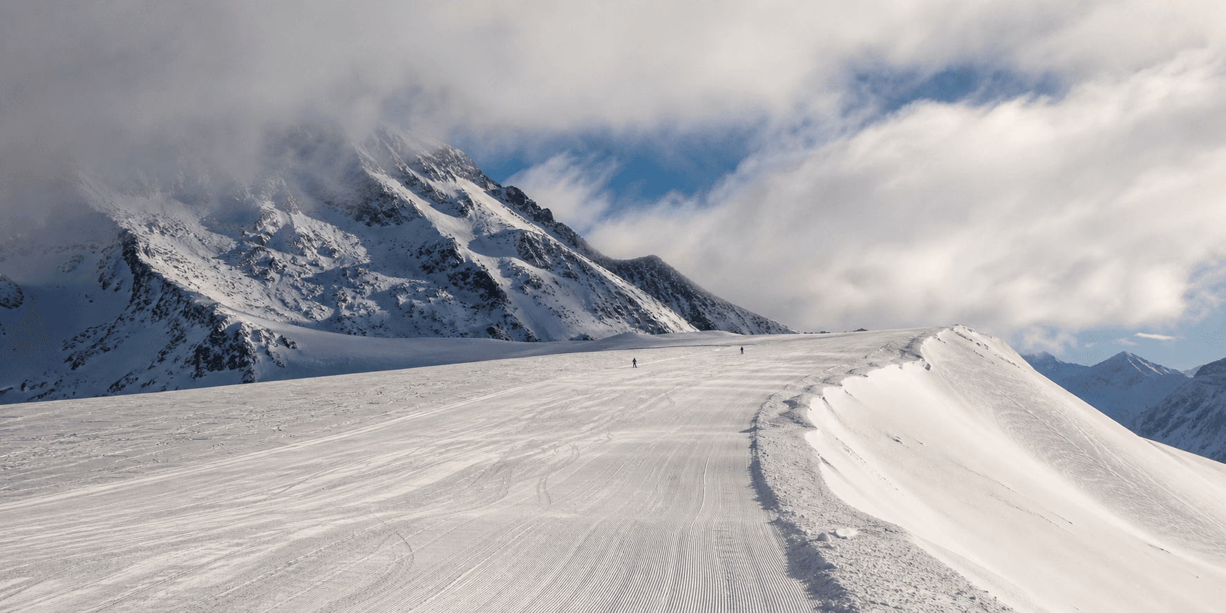 A broad mountain slope beneath broken cloud in a sample morning condition report.