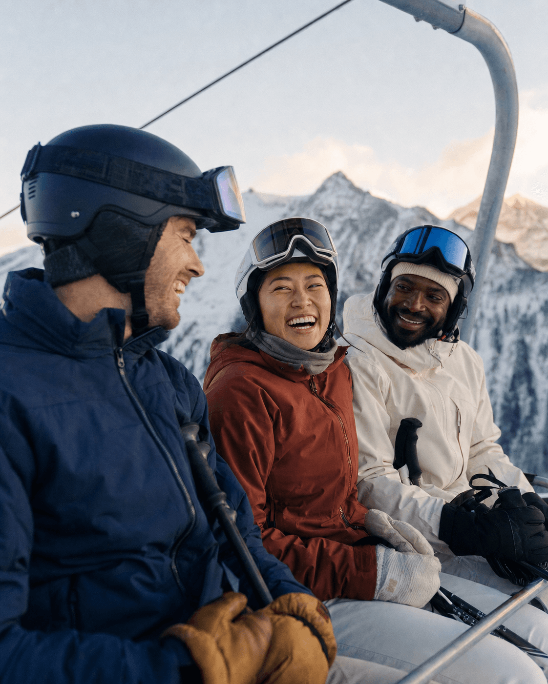 Three friends sharing a quiet chairlift ride after fresh snowfall.