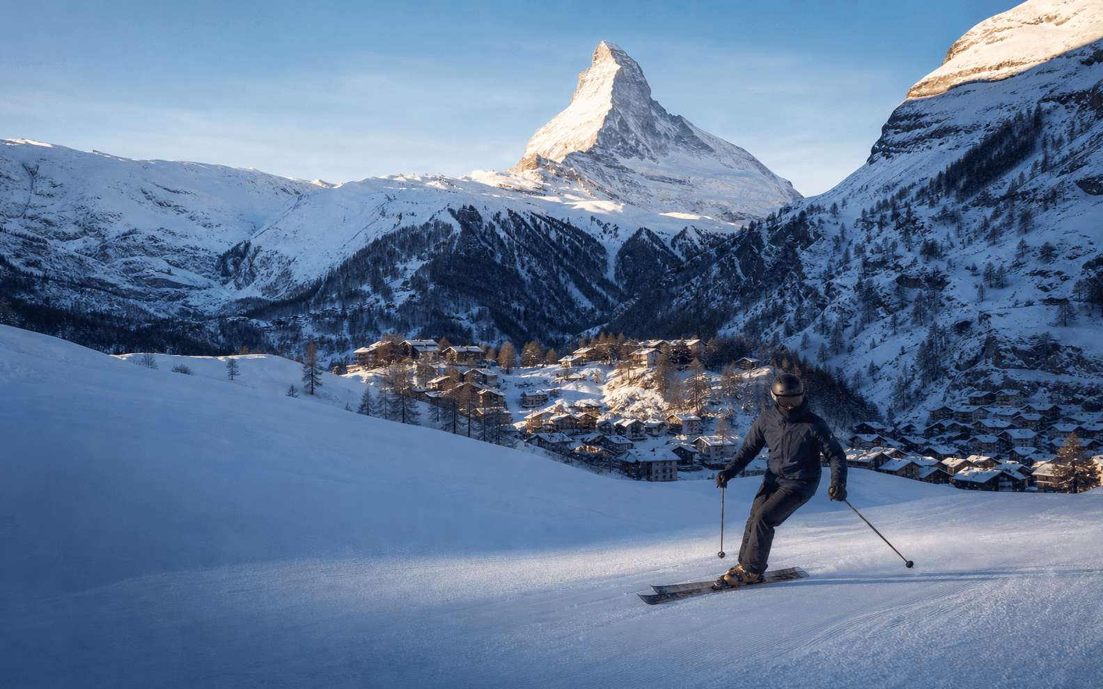 A skier crossing a pristine Zermatt piste beneath the Matterhorn.